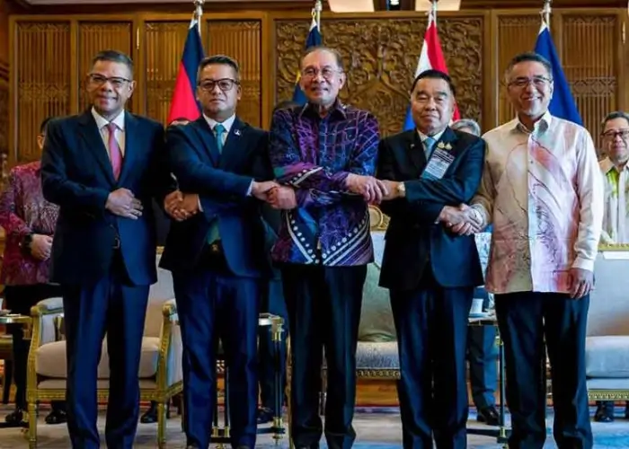 Ketua ASEAN yang juga PM Malaysia Anwar Ibrahim berjabat tangan dengan Menteri Pertahanan Tea Seiha dan Penjabat Menteri Pertahanan Thailand Nattaphon Narkphanit, menjelang pertemuan luar biasa GBC. (Apnews.com)