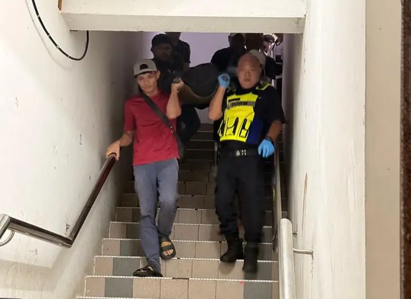 Petugas Polisi Daerah Kuching mengangkat kantong jenazah pria asal Indonesia untuk dibawa ke Hospital Umum Sarawak, Kuching.