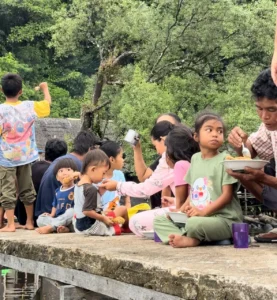 Anak-anak nelayan menikmati hidangan ayam goreng dari Tenda Makan Gratis di Dusun Peninjau