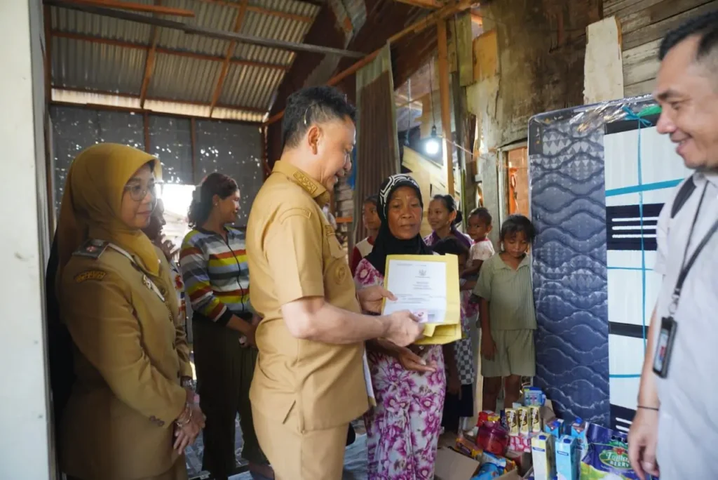 Wali Kota Pontianak Edi Rusdi Kamtono menyerahkan dokumen kependudukan kepada Norma, warga penerima bantuan bedah rumah.