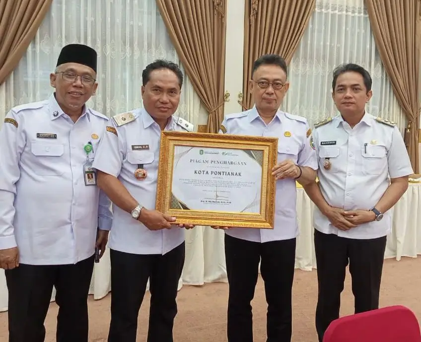 Kepala Dinas Tenaga Kerja Kota Pontianak, Ismail menyerahkan piagam Paritrana Award BPJS Ketenagakerjaan yang diterimanya kepada Wali Kota Pontianak Edi Rusdi Kamtono.