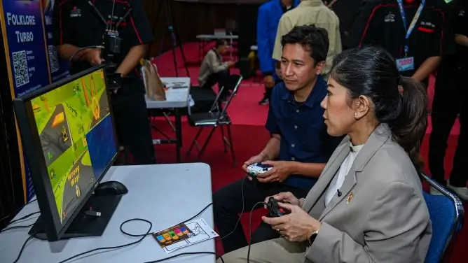 Menkomdigi Meutya Hafid memainkan salah satu gim karya mahasiswa dalam GameTech Exhibition di STMM MMTC Yogyakarta, Sabtu (20/09/2025). (Foto: Pey HS/Komdigi)