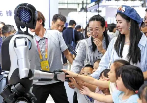 Pengunjung berinteraksi dengan robot layanan rumah selama World Smart Industry Expo 2025 di Chongqing pada 6 September. (CHEN CHENG/XINHUA)