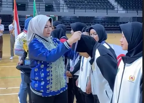 Kepala Disporapar Kalbar Windy Prihastari mengalungkan medali kepada atlet pada penutupan Kejurnas Bola Tangan 2025 di Pontianak. (instagram.com/disporaparkalbar)