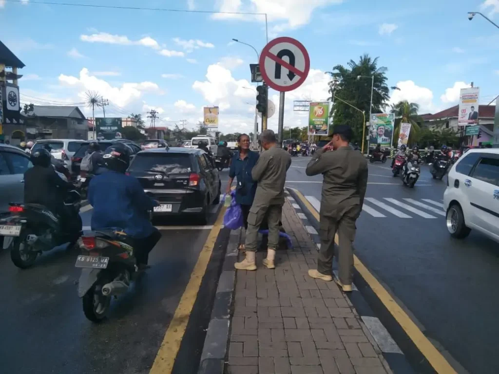 Petugas Satpol PP Kota Pontianak menertibkan pengemis yang meminta-minta di persimpangan lampu merah.