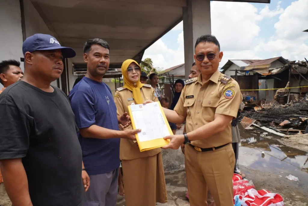 Wali Kota Pontianak Edi Rusdi Kamtono didampingi Kepala Disdukcapil Kota Pontianak Erma Suryani menyerahkan secara simbolis dokumen kependudukan kepada korban kebakaran.