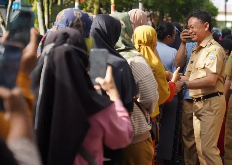 Wali Kota Pontianak Edi Rusdi Kamtono menyapa warga yang tengah mengantre untuk membeli paket sembako murah di Operasi Pasar Murah yang digelar di Kecamatan Pontianak Timur.
