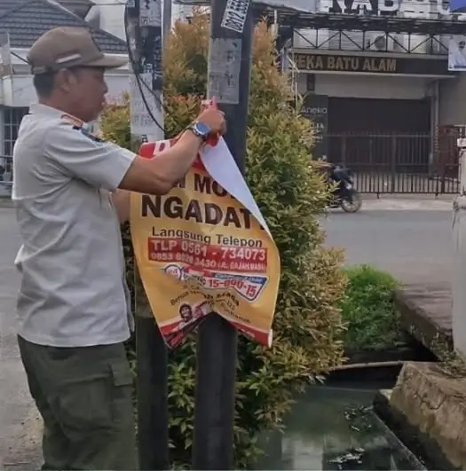 Petugas Satpol PP Pontianak menertibkan pamflet dan reklame liar yang dipasang di tiang listrik dan fasilitas umum. (instagram.com/polpp.ptk)
