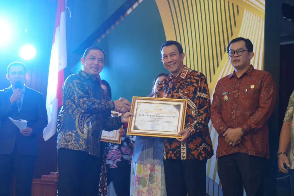 Kepala Dinas Komunikasi dan Informatika Kota Pontianak Zulkarnain saat menerima piagam penghargaan dari Komisi Informasi Provinsi Kalbar.