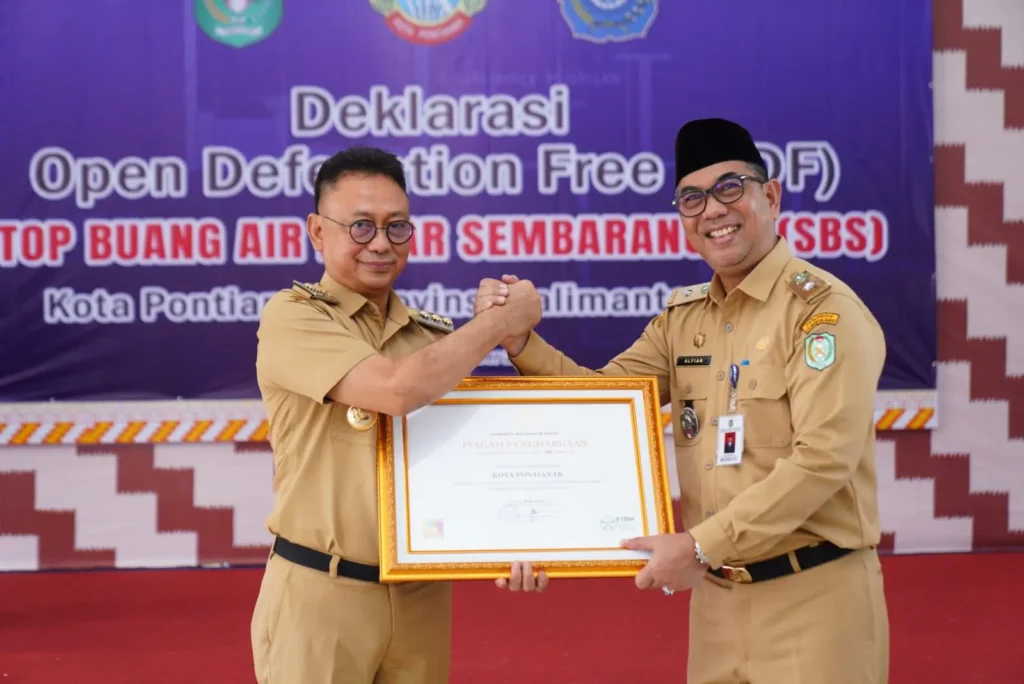 ⁠Asisten Administrasi dan Umum Sekretariat Daerah Provinsi Kalbar Alfian Salam menyerahkan Sertifikat status ODF kepada Wali Kota Pontianak Edi Rusdi Kamtono.