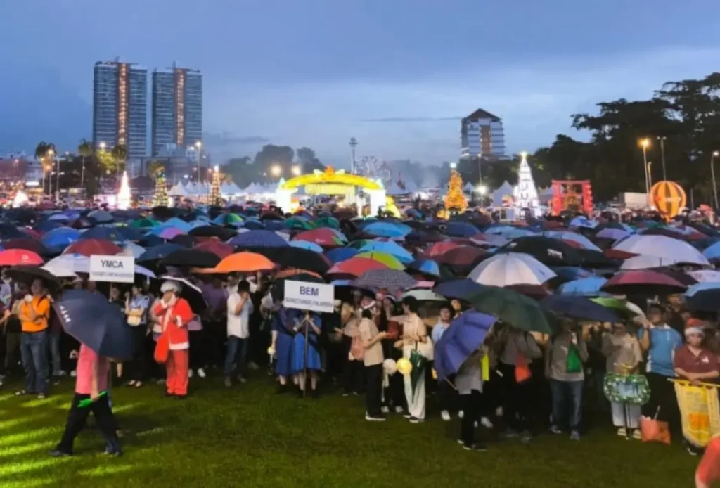 Peserta Pawai Natal ACS Sibu 2025 tetap antusias mengikuti prosesi meski diguyur hujan di pusat Kota Sibu, Sarawak. (Dok. Borneo Post)