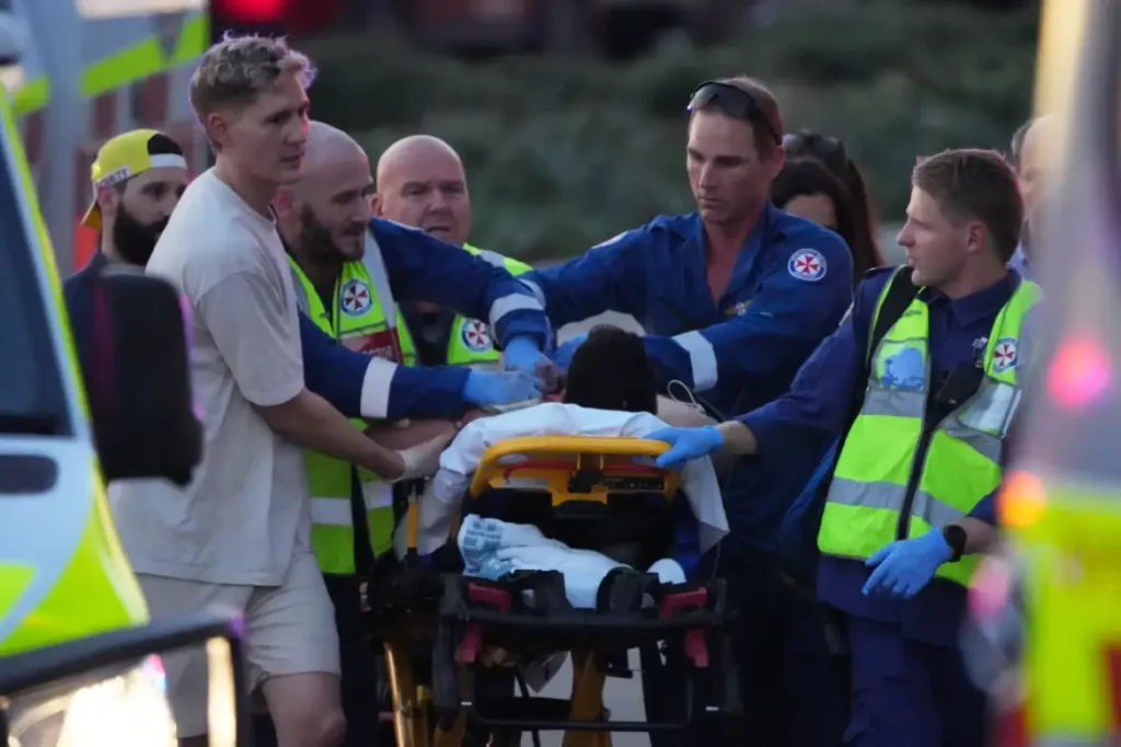 Petugas medis mengevakuasi korban penembakan di Pantai Bondi, Sydney. (Mark Baker/AP)