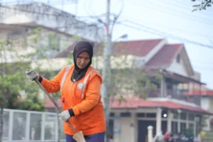 Wahideh (58) menjalankan tugasnya menyapu jalan setiap pagi.
