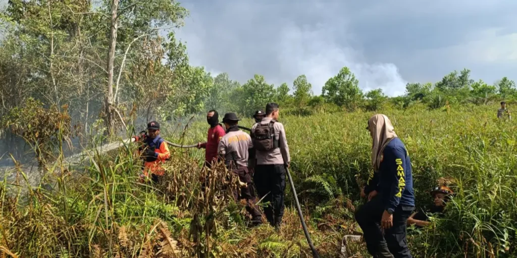 Petugas Sat Samapta Polresta Pontianak dan BPBD Kalbar memadamkan kebakaran lahan di Parit Demang Dalam.