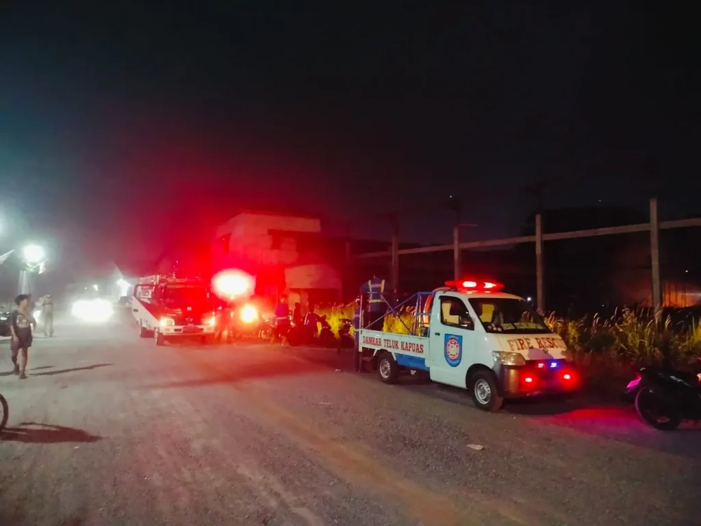 Petugas pemadam kebakaran berusaha memadamkan kobaran api di gudang PT Putra Borneo Barat.