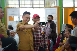 Momen Wali Kota Pontianak Edi Rusdi Kamtono berswafoto dengan warga penerima bantuan.