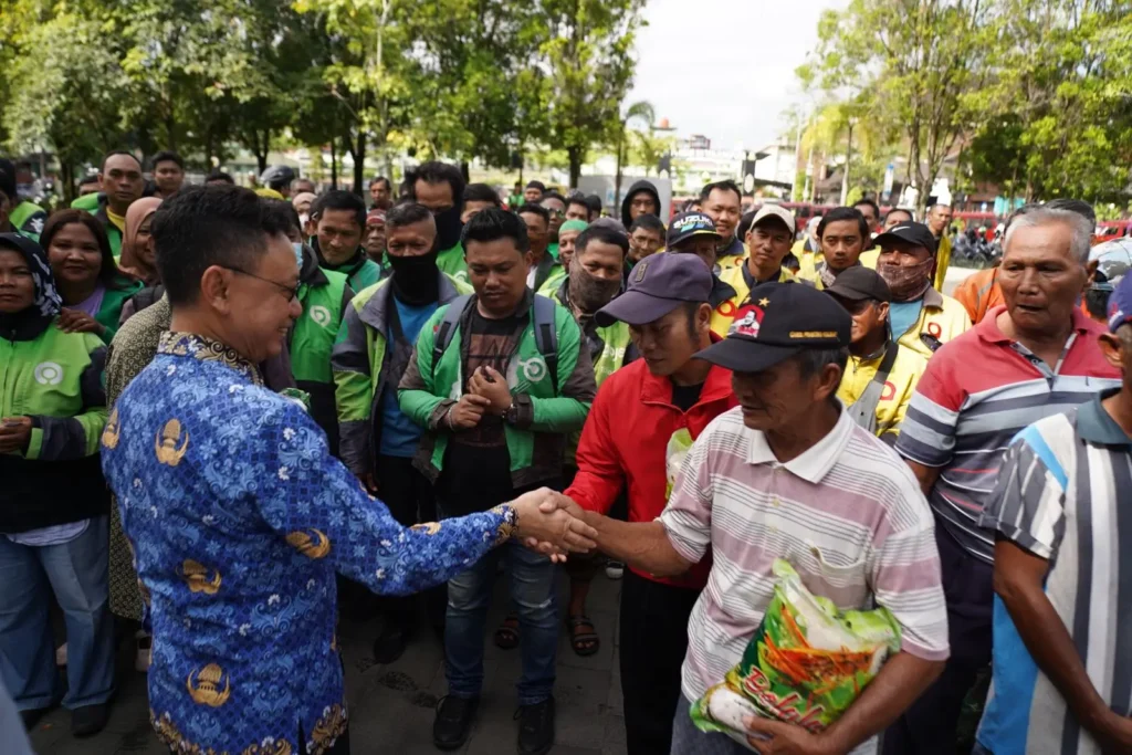 Wali Kota Pontianak Edi Rusdi Kamtono menyerahkan bantuan beras kepada Deris Landuk, penambang sampan tradisional.
