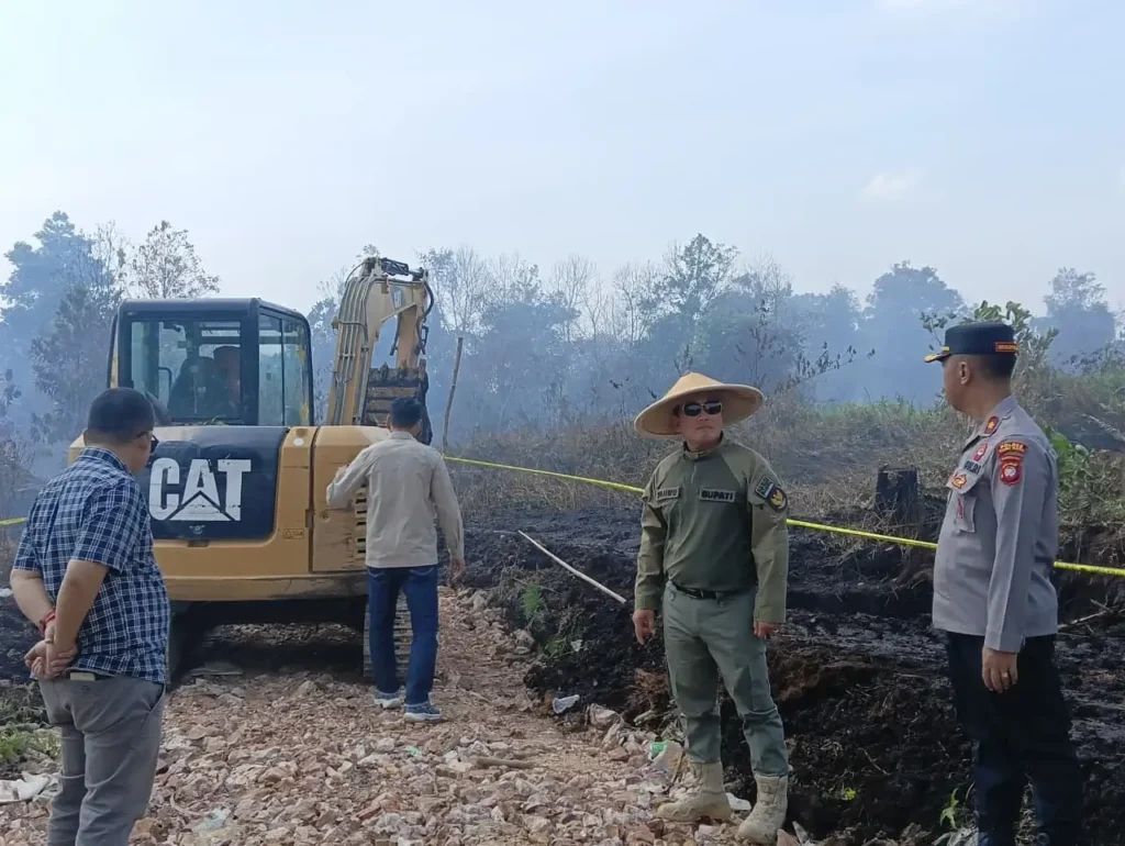 Polisi memasang garis polisi di lokasi lahan terbakar di Sungai Raya Kubu Raya, (26/3/2026).