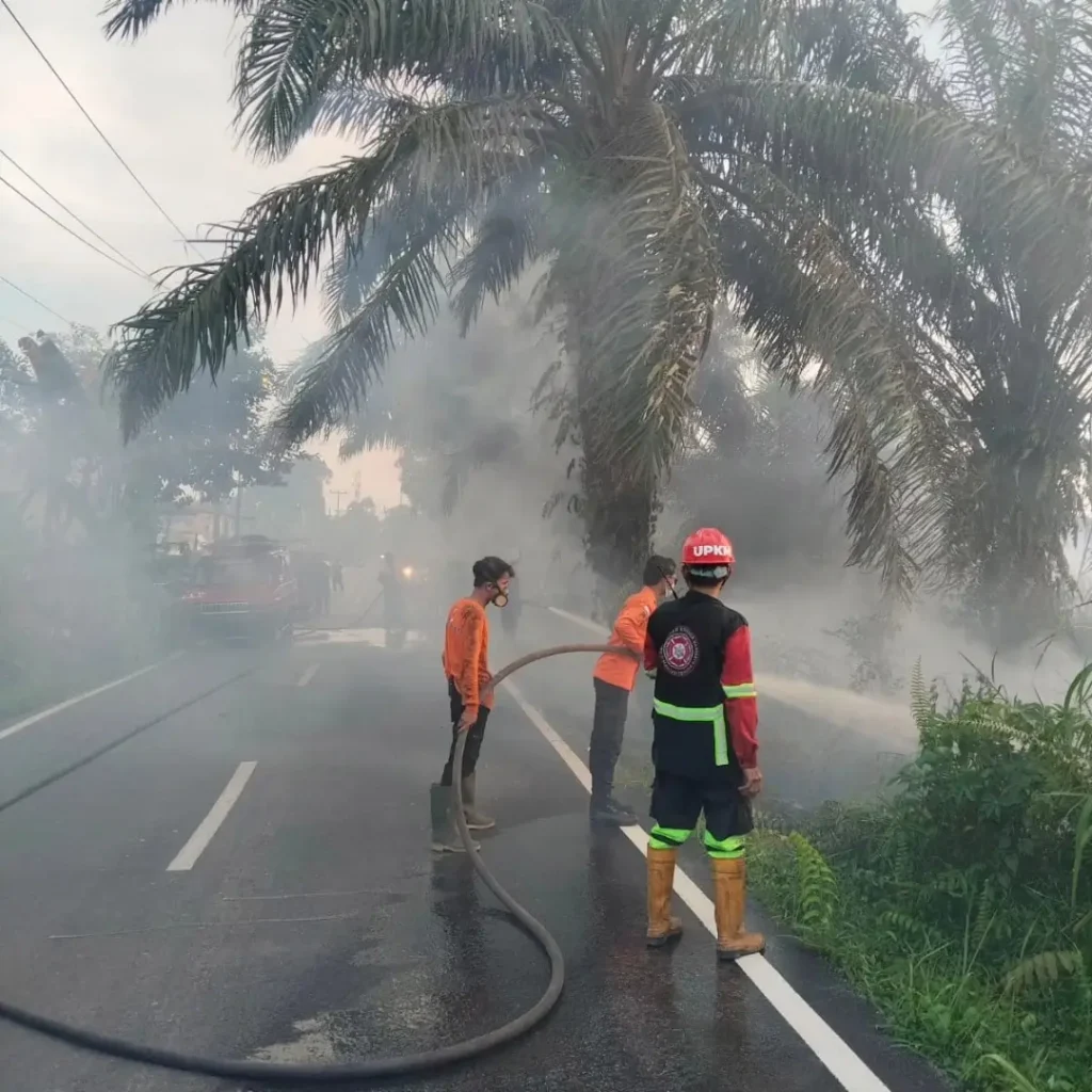 Petugas Polsek Pontianak Utara bersama Pemadam Kebakaran Kota Pontianak memadamkan lahan gambut yang terbakar di kawasan Batulayang, Pontianak Utara.