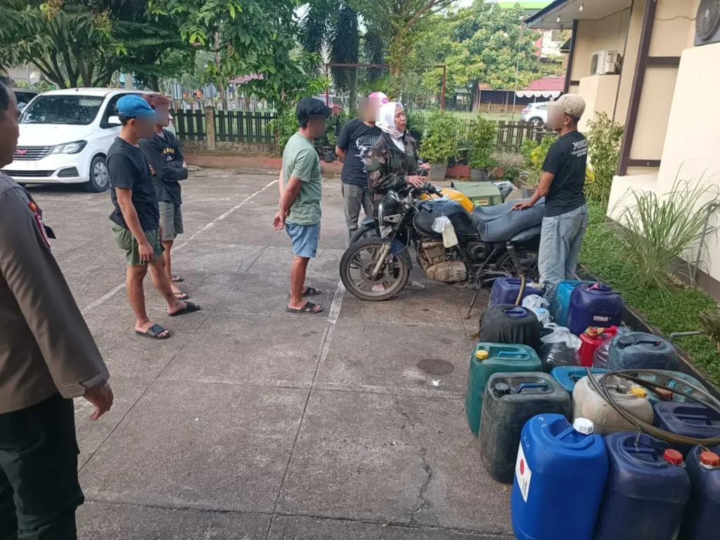 Petugas Polsek Pontianak Selatan menunjukkan sepeda motor dengan tangki modifikasi dan jerigen berisi Pertalite sebagai barang bukti penyalahgunaan BBM bersubsidi di Pontianak.