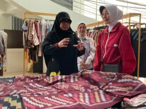 Ketua Dekranasda Kota Pontianak Yanieta Arbiastutie tengah menjelaskan hasil kerajinan kain tenun corak insang kepada Ketua DWP Kementerian Lingkungan Hidup, Sulikah.