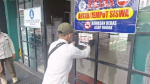 Tim Satgas Kawasan Tanpa Rokok (KTR) tengah menempelkan tanda larangan merokok sebagai implementasi Perda Nomor 4 Tahun 2025 tentang KTR.