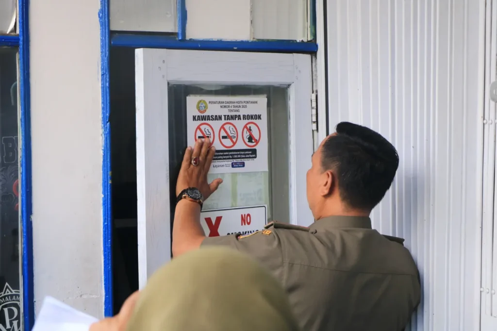 Tim Satgas Kawasan Tanpa Rokok (KTR) tengah menempelkan tanda larangan merokok sebagai implementasi Perda Nomor 4 Tahun 2025 tentang KTR.
