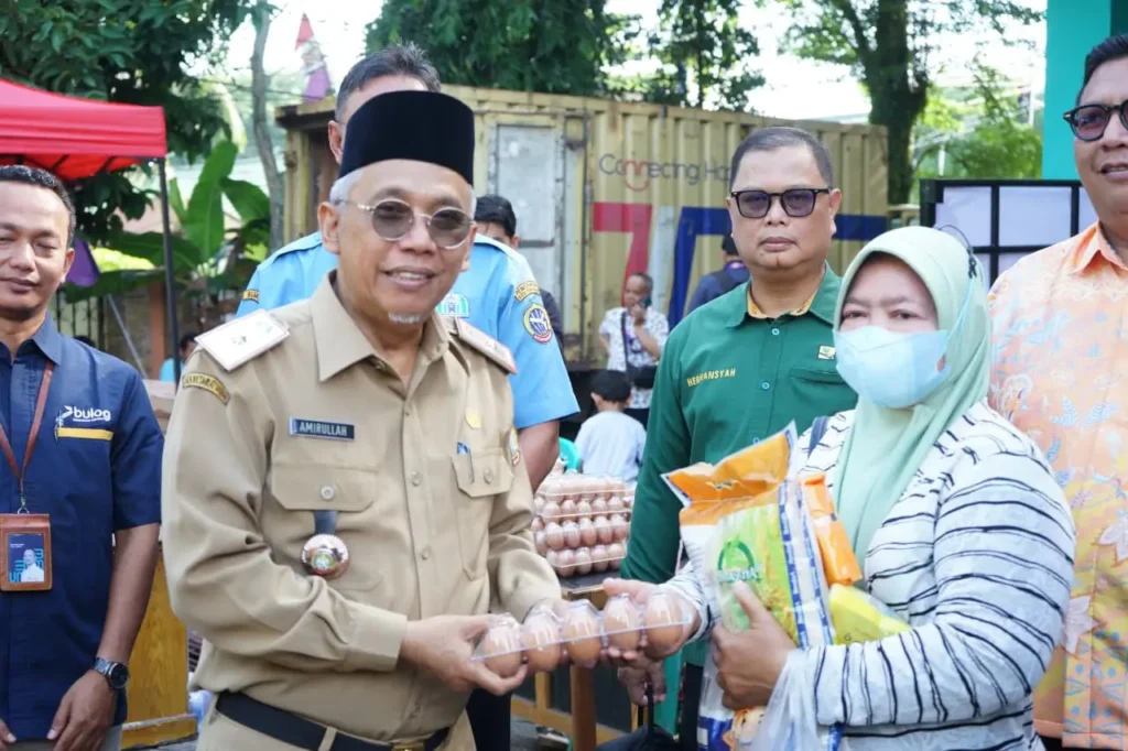 Sekretaris Daerah Kota Pontianak Amirullah menyerahkan paket sembako kepada pembeli pertama Operasi Pasar Jelang Iduladha di halaman Kantor Camat Pontianak Barat, Selasa (19/5/2026).