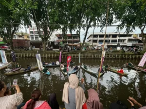 Penampilan Grup Tanjidor Sumber Rezeki di atas sampan dalam Habe Fest 2026 di Sungai Jawi Pontianak.