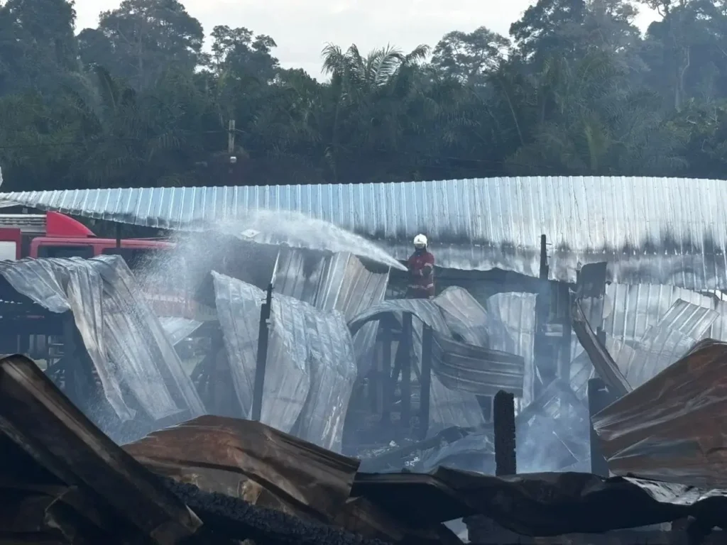 Petugas pemadam kebakaran berupaya memadamkan api yang melahap rumah panjang di Kampung Labau, Sarawak menjelang perayaan Hari Gawai.