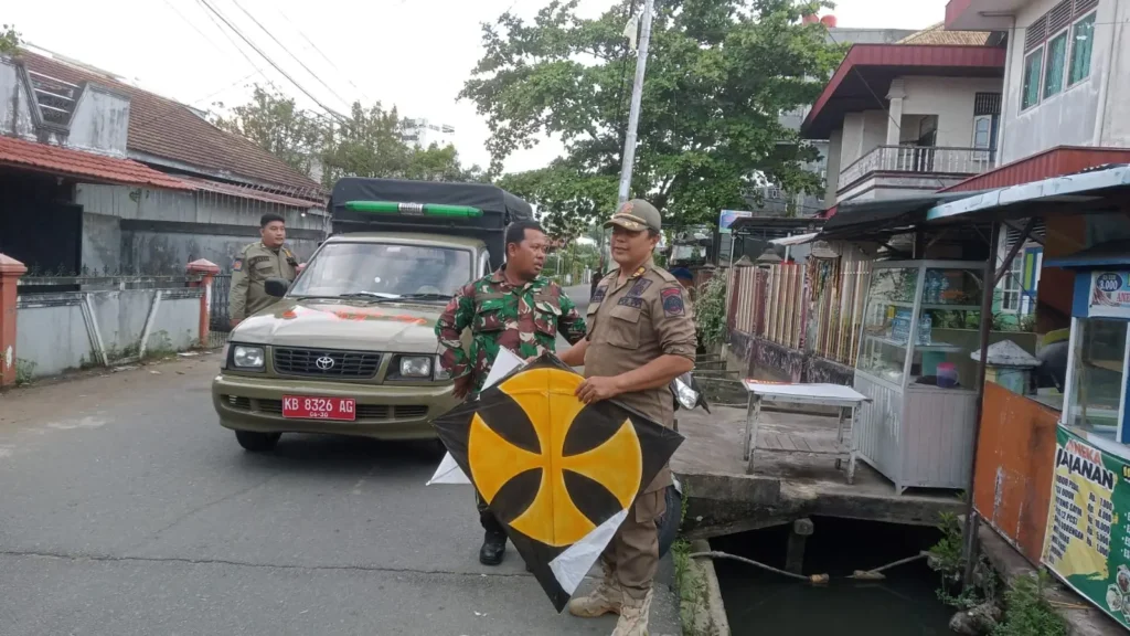 Tim Penertiban tengah mengamankan layangan dan perlengkapannya yang terjaring dalam penertiban.