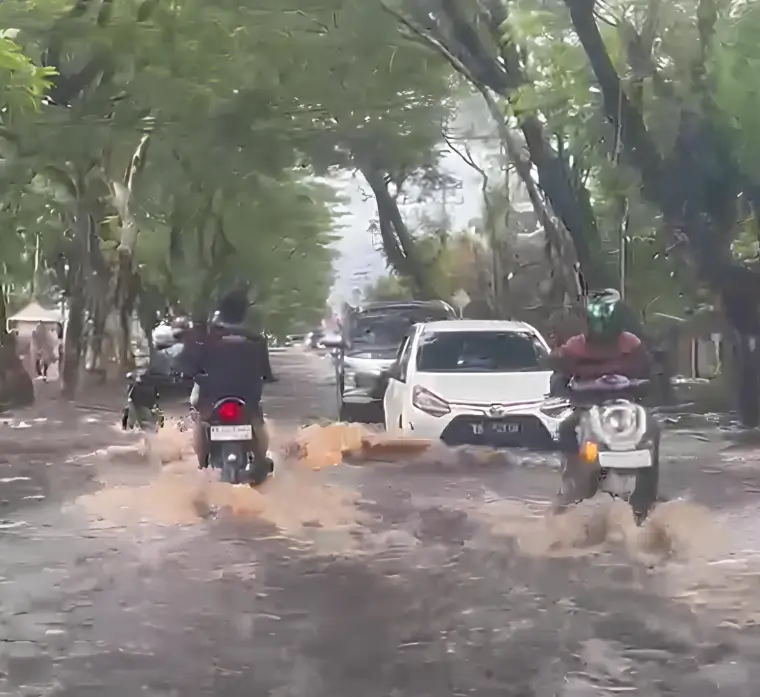 Genangan banjir merendam Jalan Perdana Pontianak akibat hujan deras dan air pasang Sungai Kapuas yang terjadi bersamaan.