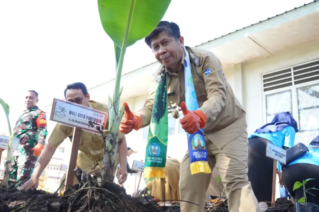 Plh Kepala Dinas Lingkungan Hidup Kota Pontianak, Muchammad Yamin, melakukan penanaman pohon secara simbolis saat peluncuran Program Digulis Ceria di SMPN 8 Pontianak.