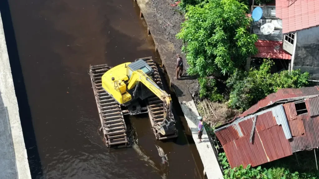 Dinas PUPR Kota Pontianak menerjunkan eskavator amfibi untuk mengeruk parit agar memperlancar aliran air.