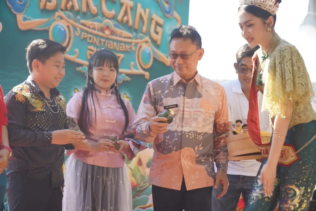 Wali Kota Pontianak Edi Rusdi Kamtono menyerahkan bakcang kepada warga dalam Festival 1.000 Bakcang Pontianak di Taman Alun Kapuas, Jumat (19/6/2026). Dalam festival ini turut dibagikan 1.000 bakcang gratis kepada para pengunjung.
