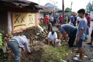 Warga bergotong royong membersihkan lingkungan.