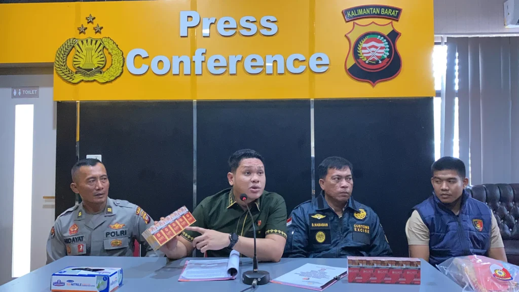 Petugas Polres Singkawang menunjukkan ratusan slop rokok GATI hasil penggerebekan gudang rokok ilegal di Singkawang Utara.