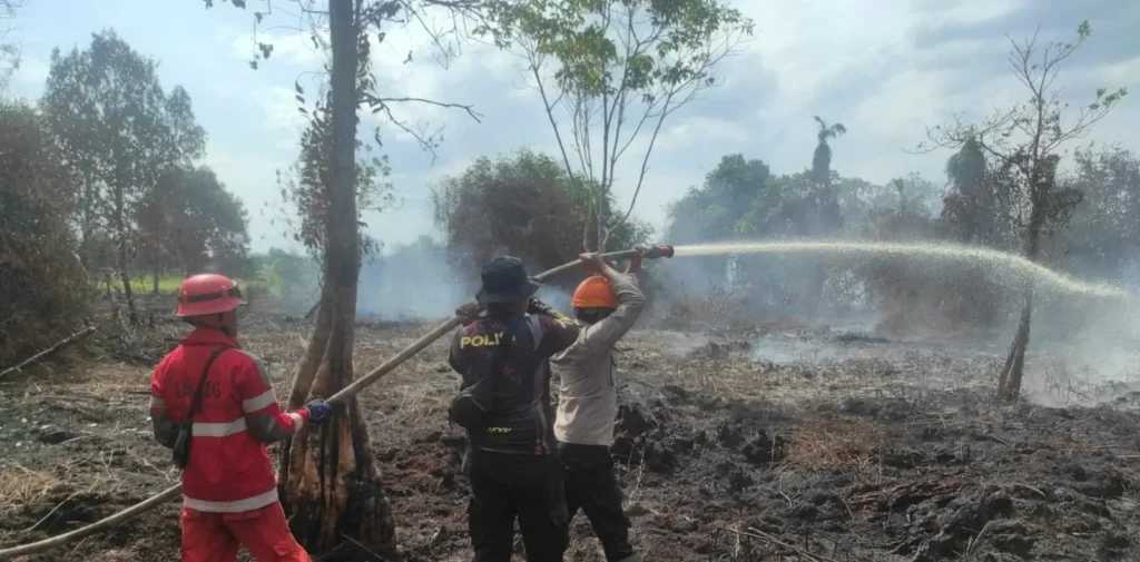 Personel Polres Kubu Raya bersama tim gabungan memadamkan kebakaran hutan dan lahan di Kecamatan Rasau Jaya, Kabupaten Kubu Raya.
