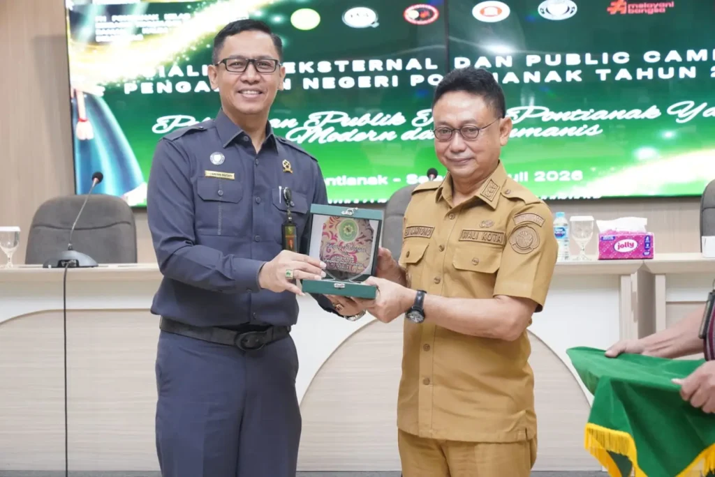Ketua Pengadilan Negeri Pontianak I Dewa Gede Budhy Dharma Asmara menyerahkan cinderamata kepada Wali Kota Pontianak Edi Rusdi Kamtono usai pembukaan Sosialisasi Eksternal dan Public Campaign Pengadilan Negeri Pontianak di Aula SSA Kantor Wali Kota Pontianak, Selasa (7/6/2026).