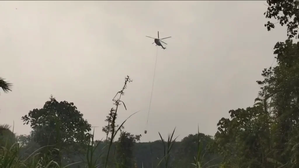 Polisi dan warga menangani karhutla di Simpang Hilir Kayong Utara dengan dukungan water bombing. (Foto: Res-KKU)