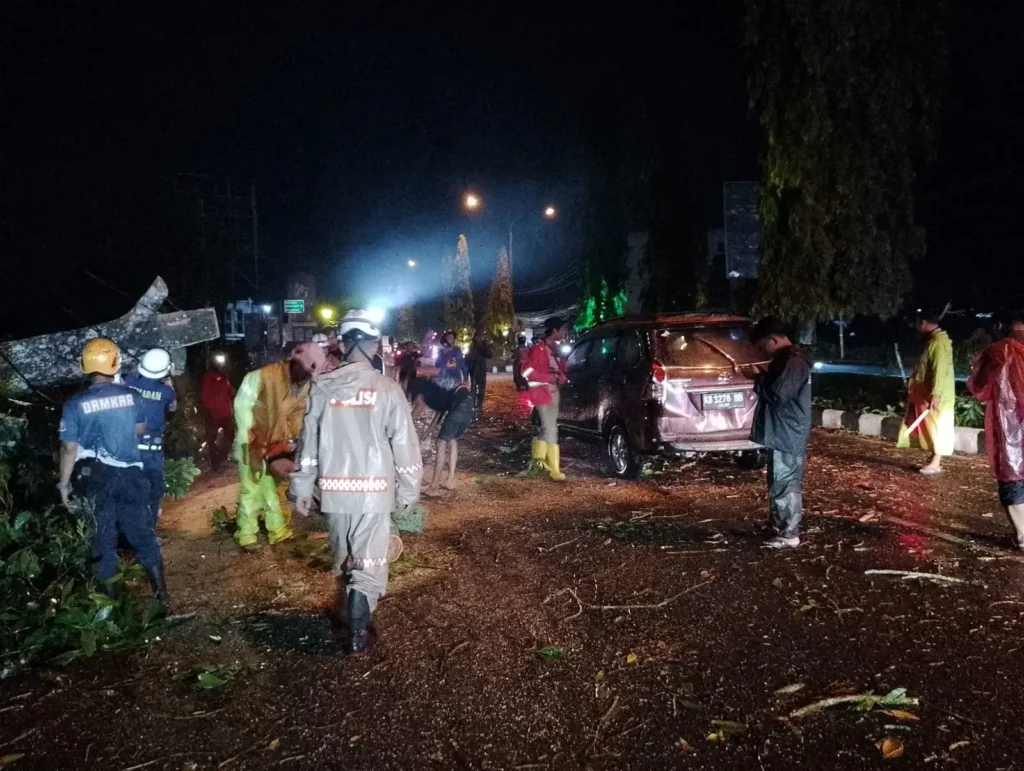 Petugas gabungan mengevakuasi pohon tumbang yang menghantam minibus di depan Qubu Resort, Jalan Arteri Supadio, Kabupaten Kubu Raya.