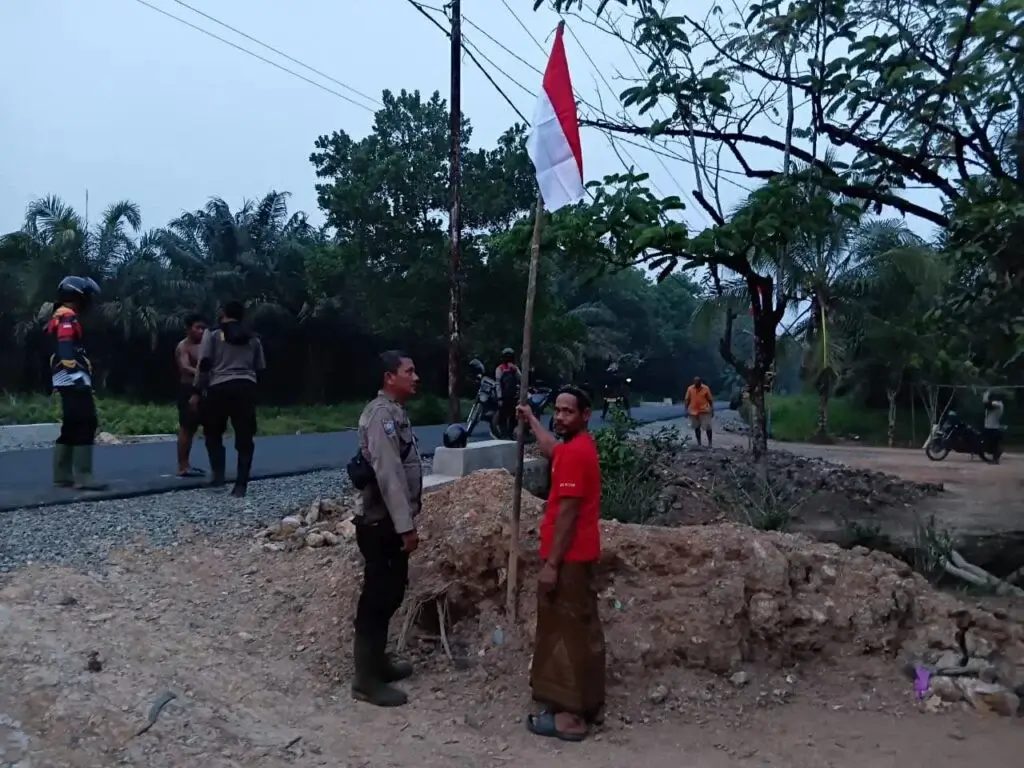 Polsek Sungai Ambawang membagikan dan membantu memasang Bendera Merah Putih di rumah warga menjelang HUT ke-81 RI.