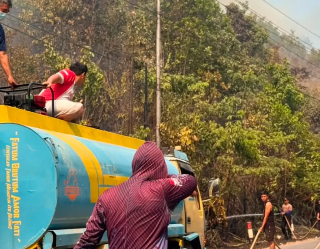 Petugas dan warga memadamkan kebakaran di Bukit Matok Melawi