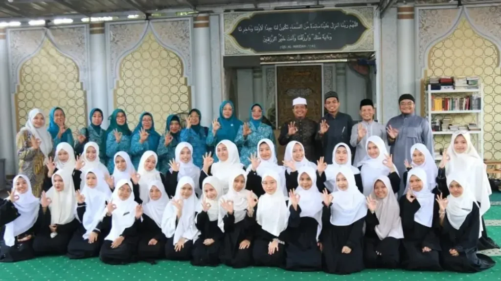 Ketua TP PKK Kalbar Ny. Erlina Ria Norsan menyerahkan bantuan sembako dan perlengkapan salat kepada santri Sekolah Qur’an Keluarga Kita di Pontianak.