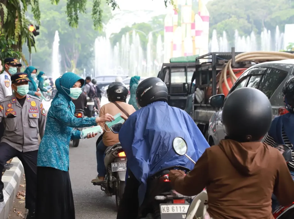 Ketua TP PKK Kota Pontianak membagikan masker kepada pengendara sepeda motor di kawasan bundaran Tugu Digulis Untan, Rabu (19/8/2026).
