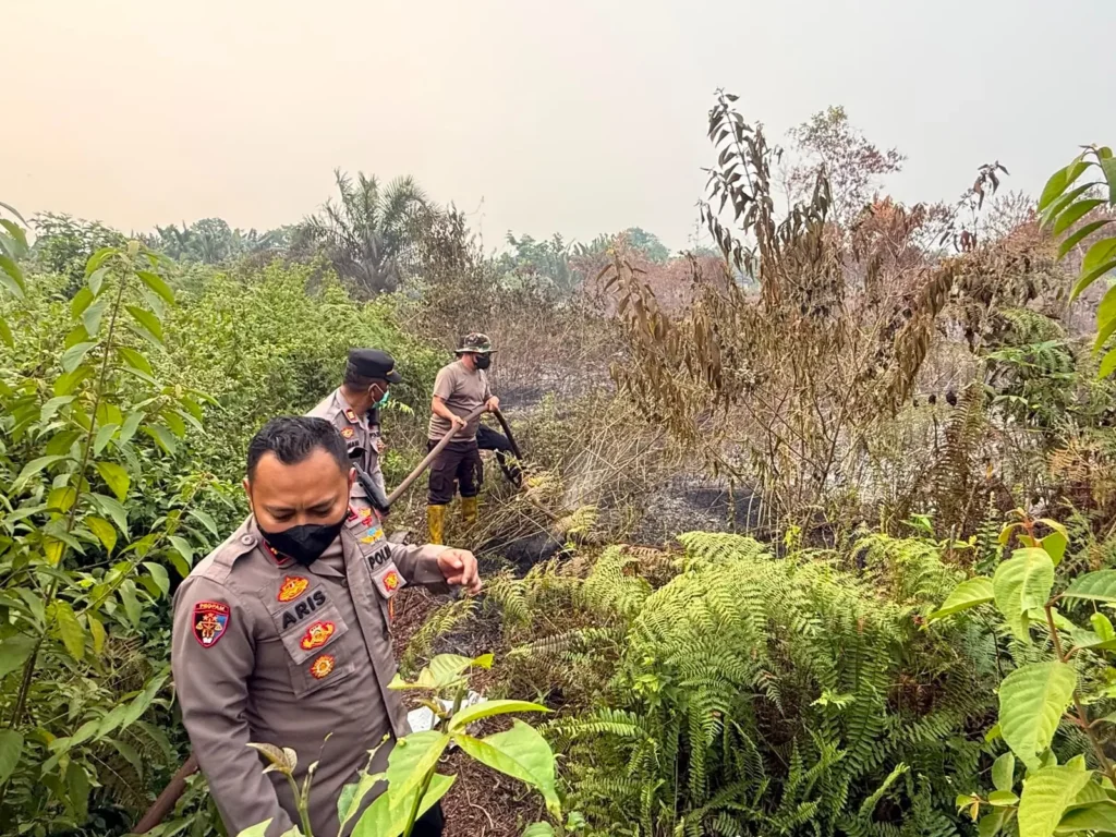 Polisi dan warga berjibaku memadamkan karhutla di kawasan Jalan Sungai Selamat, Pontianak Utara. (Foto: Res-Pontianak)