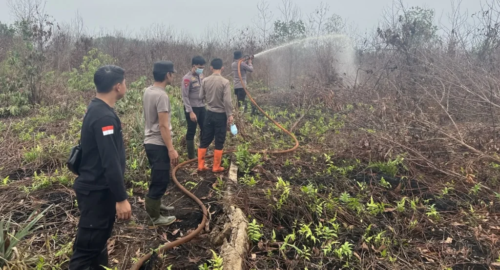 Polisi melakukan pendinginan bekas karhutla di Desa Limbung Kubu Raya. (Foto: Res-KKR)