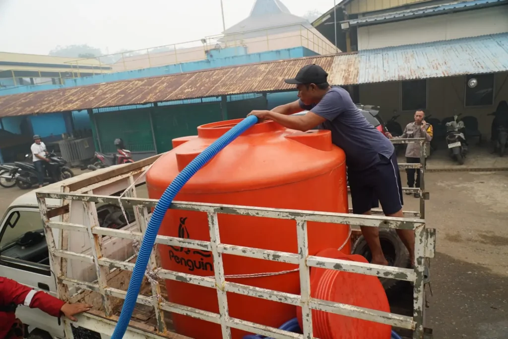 Mobil pikup berisi tong tengah diisi air bersih dari IPA 3 booster Imam Bonjol, Kantor Perumda Tirta Khatulistiwa untuk selanjutnya didistribusikan ke warga, Selasa (15/9/2026) sore.