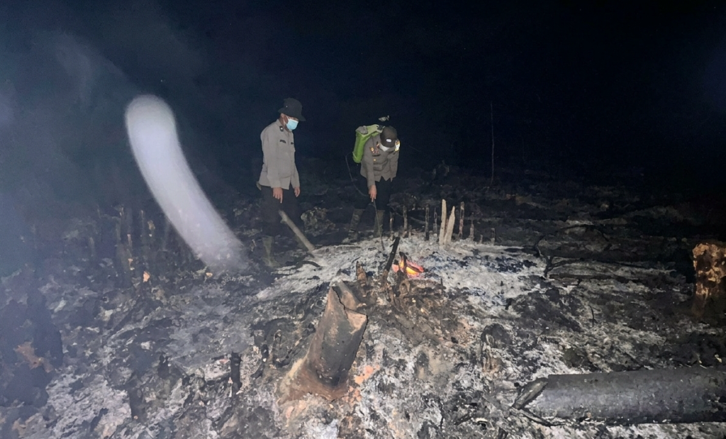 Personel Polsek Tayan Hulu melakukan pengecekan titik panas di lahan seluas sekitar 0,6 hektare di Dusun Tonggong, Desa Menyabo, Kabupaten Sanggau, Sabtu (10/10/2026) malam, untuk memastikan api telah padam dan mencegah karhutla meluas. (Foto: Res-Sgu)