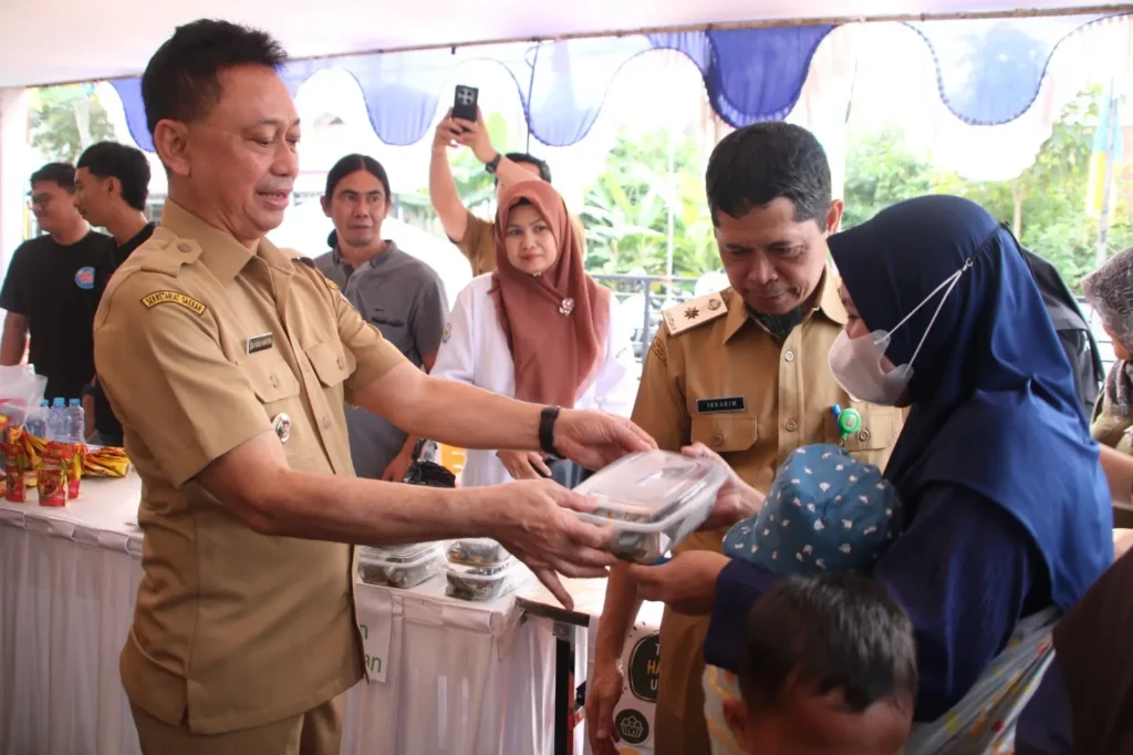 Wali Kota Pontianak Edi Rusdi Kamtono melayani warga yang berbelanja di pasar murah di halaman Kantor Camat Pontianak Selatan (20/10/2026).